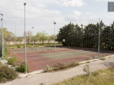 Il viale d�ingresso ci porta subito davanti ai desertici campi sportivi, privati di tutto i loro elementi caratteristici: in quello da tennis non rimane pi� alcuna traccia della rete, su quelli da calcio sono state portate via le porte...